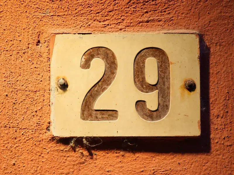 Un numéro de maison en laiton fixé sur un mur