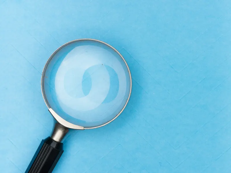 Une loupe posée sur une table blanche